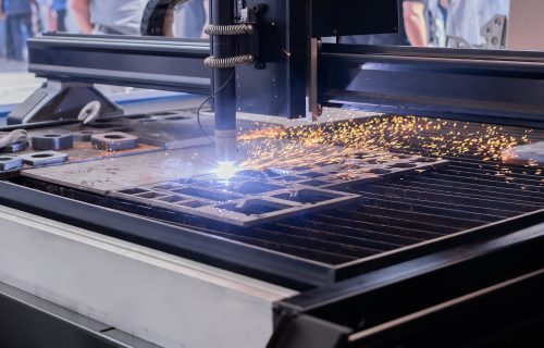 CNC plasma cutter – cutting steel sheet with sparks in a trade fair hall