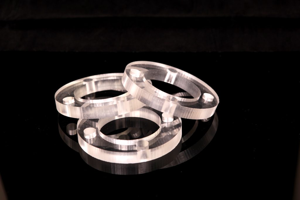 Three CNC-milled PMMA Plexi rings, front view - 4 mounting holes visible in each flange