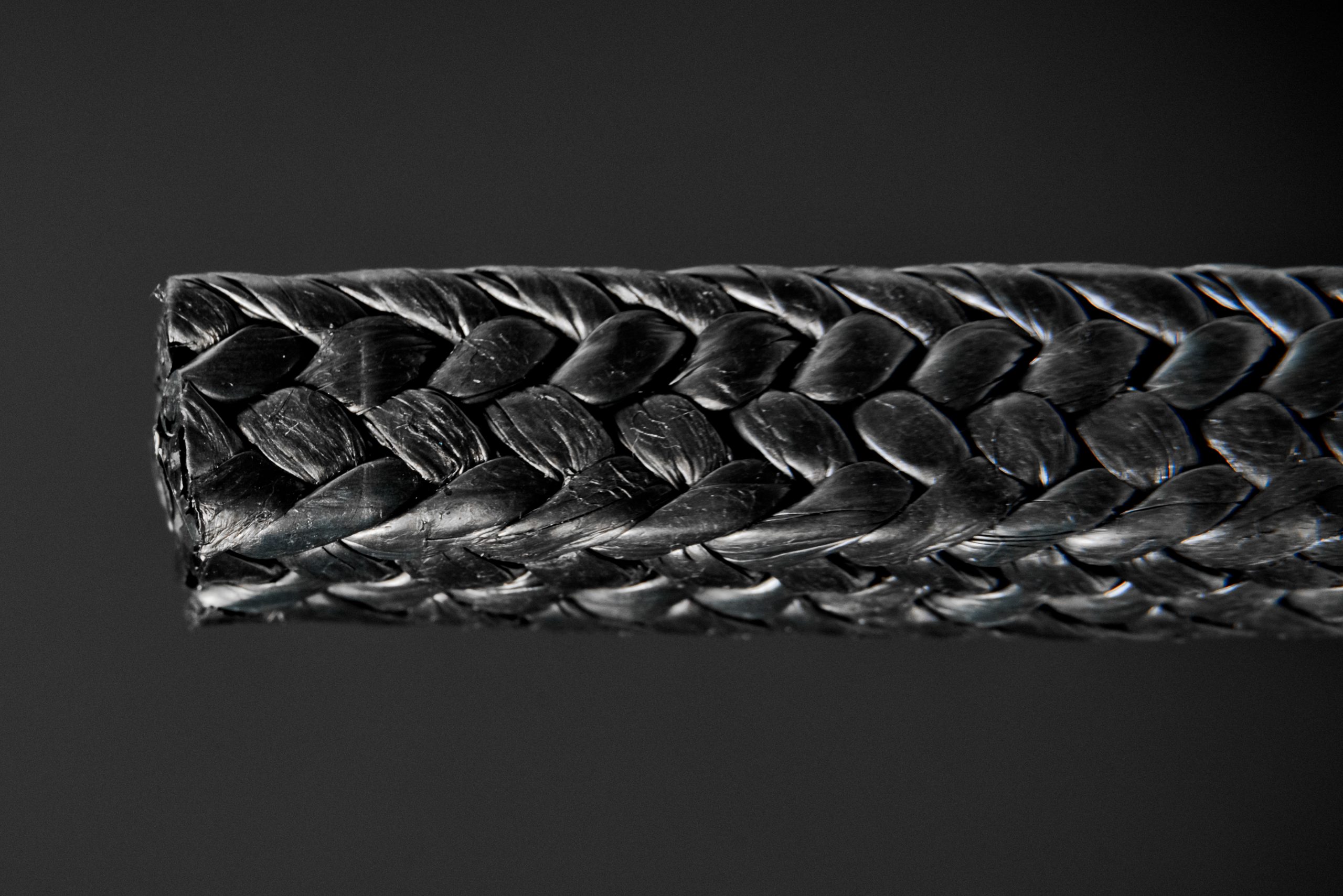 Macro of black graphite packing with herringbone braid - PTFE-graphite for pumps and valves