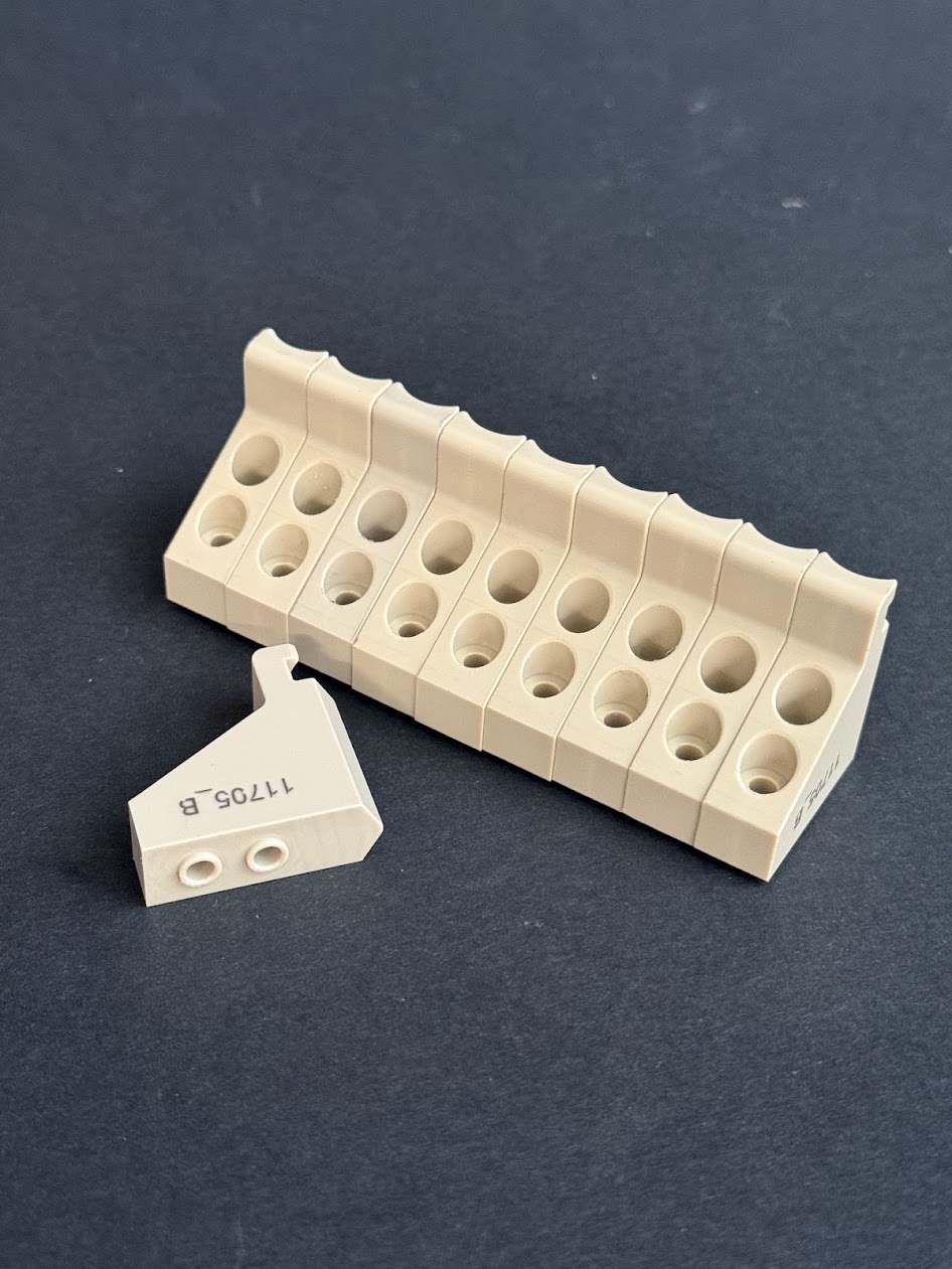 Beige plastic wedges with holes and the number bst lying against a dark background, with one module turned on its side.